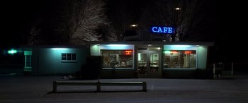 Movie still from “Kill Bill: Vol. 2” (2004), directed by Quentin Tarantino – A night time view of a cafe in the dark; Extreme Wide shot, High angle