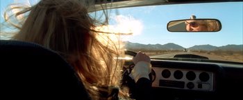 Movie still from “Kill Bill: Vol. 2” (2004), directed by Quentin Tarantino – A woman is driving a car in the sunlight; Close Up shot, Low angle