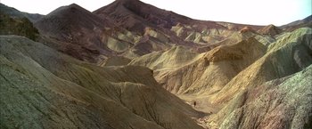 Movie still from “Kill Bill: Vol. 2” (2004), directed by Quentin Tarantino – A man riding a bike through a desert landscape; Extreme Wide shot, High angle