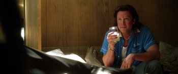 Movie still from “Kill Bill: Vol. 2” (2004), directed by Quentin Tarantino – A woman sitting on a couch holding a glass of milk; Close Up shot, Over the shoulder angle