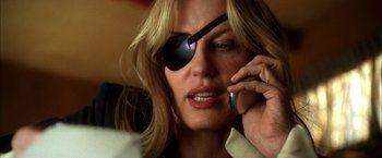 Movie still from “Kill Bill: Vol. 2” (2004), directed by Quentin Tarantino – A woman wearing a eye patch while talking on a cell phone; Close Up shot, Low angle