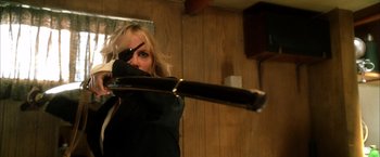 Movie still from “Kill Bill: Vol. 2” (2004), directed by Quentin Tarantino – A woman holding a baseball bat in a room; Close Up shot, Low angle