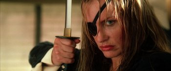 Movie still from “Kill Bill: Vol. 2” (2004), directed by Quentin Tarantino – A person holding a sword and wearing a eye patch; Close Up shot, Low angle