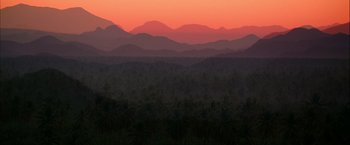 Movie still from “Kill Bill: Vol. 2” (2004), directed by Quentin Tarantino – A view of a mountain range at sunset with palm trees in the foreground; Extreme Wide shot, High angle