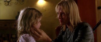 Movie still from “Kill Bill: Vol. 2” (2004), directed by Quentin Tarantino – A woman is putting something on a little girl's face; Close Up shot, Over the shoulder angle