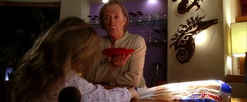 Movie still from “Kill Bill: Vol. 2” (2004), directed by Quentin Tarantino – An older woman holding a bowl of food near a young girl; Medium shot, Over the shoulder angle