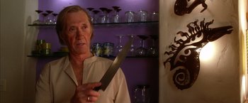 Movie still from “Kill Bill: Vol. 2” (2004), directed by Quentin Tarantino – An older man holding a knife in front of his face; Close Up shot, Low angle