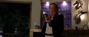 Movie still from “Kill Bill: Vol. 2” (2004), directed by Quentin Tarantino – A man holding a gun in his right hand; Medium shot, Low angle