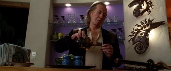 Movie still from “Kill Bill: Vol. 2” (2004), directed by Quentin Tarantino – A man is pouring a drink into a glass; Medium shot, Low angle
