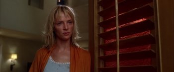 Movie still from “Kill Bill: Vol. 2” (2004), directed by Quentin Tarantino – A woman with blonde hair wearing an orange scarf; Close Up shot, Low angle