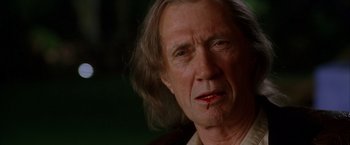 Movie still from “Kill Bill: Vol. 2” (2004), directed by Quentin Tarantino – An older man with long blonde hair and a bruised face; Close Up shot, Low angle