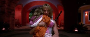 Movie still from “Kill Bill: Vol. 2” (2004), directed by Quentin Tarantino – A woman holding a child with a sword in her arms; Medium shot, Low angle