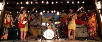 Movie still from “Kill Bill: Vol. 2” (2004), directed by Quentin Tarantino – A group of people playing musical instruments on a stage; Wide shot, High angle