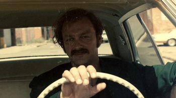 Movie still from “Kill the Irishman” (2011), directed by Jonathan Hensleigh – A man driving a car in the rain; Close Up shot, Low angle