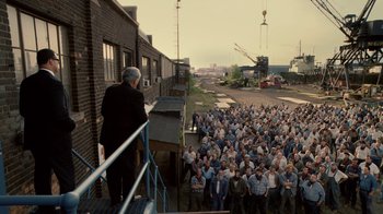 Movie still from “Kill the Irishman” (2011), directed by Jonathan Hensleigh – An older man standing on a balcony overlooking a crowd of people; Extreme Wide shot, High angle