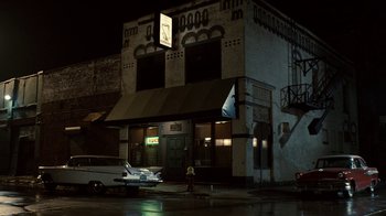 Movie still from “Kill the Irishman” (2011), directed by Jonathan Hensleigh – An old car parked in front of a building at night; Extreme Wide shot, Low angle