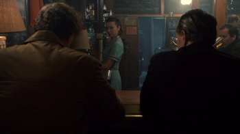 Movie still from “Kill the Irishman” (2011), directed by Jonathan Hensleigh – A woman standing in front of a mirror in front of a bar; Medium shot, Over the shoulder angle