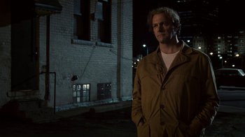 Movie still from “Kill the Irishman” (2011), directed by Jonathan Hensleigh – A man standing in front of a building at night; Medium shot, Low angle