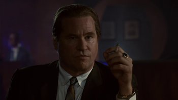 Movie still from “Kill the Irishman” (2011), directed by Jonathan Hensleigh – A person wearing a suit holding a cigarette; Close Up shot, Low angle