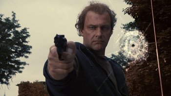 Movie still from “Kill the Irishman” (2011), directed by Jonathan Hensleigh – A man holding a gun pointed at the camera; Close Up shot, Low angle