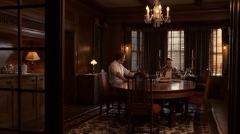 Movie still from “Kill the Irishman” (2011), directed by Jonathan Hensleigh – Two men sitting at a round dining room table; Wide shot, High angle