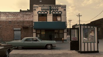 Movie still from “Kill the Irishman” (2011), directed by Jonathan Hensleigh – An old car parked on the side of the street; Extreme Wide shot, High angle