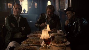Movie still from “Kill the Irishman” (2011), directed by Jonathan Hensleigh – A group of people sitting at a table with plates of food on it; Medium shot, Low angle