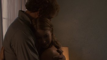 Movie still from “Kill the Irishman” (2011), directed by Jonathan Hensleigh – A man and a woman hugging in a dark room; Medium shot, Low angle