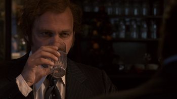 Movie still from “Kill the Irishman” (2011), directed by Jonathan Hensleigh – A man in a suit drinking a glass of water; Close Up shot, Over the shoulder angle