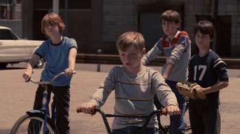 Movie still from “Kill the Irishman” (2011), directed by Jonathan Hensleigh – Three young boys are riding their bikes on the sidewalk; Medium shot, High angle