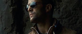 Movie still from “Killer Elite” (2011), directed by Gary McKendry – A person wearing sunglasses; Close Up shot, Low angle