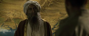Movie still from “Killer Elite” (2011), directed by Gary McKendry – An old man with a long beard wearing a turban; Close Up shot, Over the shoulder angle
