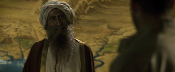 Movie still from “Killer Elite” (2011), directed by Gary McKendry – An old man with a long beard wearing a turban; Close Up shot, Over the shoulder angle