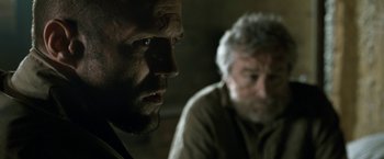 Movie still from “Killer Elite” (2011), directed by Gary McKendry – A man and an older man sitting next to each other; Close Up shot, Over the shoulder angle