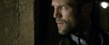 Movie still from “Killer Elite” (2011), directed by Gary McKendry – A person wearing a suit and tie; Close Up shot, Low angle