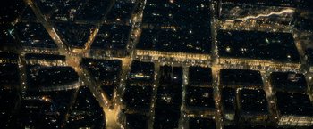 Movie still from “Killer Elite” (2011), directed by Gary McKendry – An aerial view of a city at night with lots of street lights; Extreme Wide shot, Overhead angle
