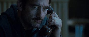 Movie still from “Killer Elite” (2011), directed by Gary McKendry – A person talking on a phone; Close Up shot, Low angle