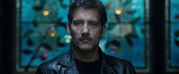 Movie still from “Killer Elite” (2011), directed by Gary McKendry – A person wearing a leather jacket; Close Up shot, Low angle