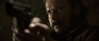 Movie still from “Killer Elite” (2011), directed by Gary McKendry – A person with a beard and mustache; Close Up shot, Over the shoulder angle