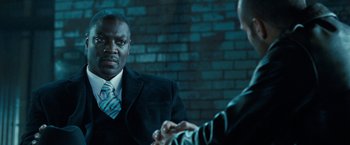 Movie still from “Killer Elite” (2011), directed by Gary McKendry – A man wearing a suit and tie talking to another man wearing a suit and tie; Close Up shot, Over the shoulder angle