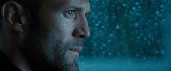 Movie still from “Killer Elite” (2011), directed by Gary McKendry – A man's face in front of a snowy background; Close Up shot, Low angle