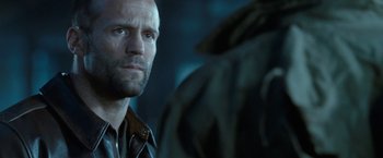 Movie still from “Killer Elite” (2011), directed by Gary McKendry – A man's face as he stares at another man; Close Up shot, Over the shoulder angle
