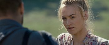 Movie still from “Killer Elite” (2011), directed by Gary McKendry – A beautiful young woman looking at the camera; Close Up shot, Over the shoulder angle