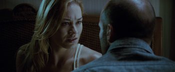 Movie still from “Killer Elite” (2011), directed by Gary McKendry – A man and a woman sitting in front of each other; Close Up shot, Over the shoulder angle