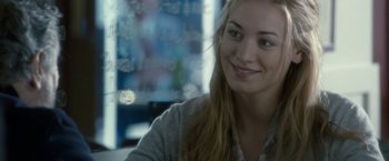 Movie still from “Killer Elite” (2011), directed by Gary McKendry – A beautiful young lady sitting in front of a window; Close Up shot, Over the shoulder angle