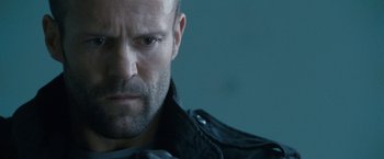 Movie still from “Killer Elite” (2011), directed by Gary McKendry – A person wearing a leather jacket; Close Up shot, Low angle