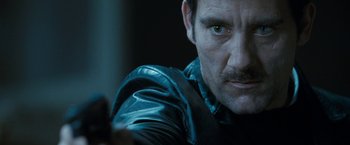 Movie still from “Killer Elite” (2011), directed by Gary McKendry – A person wearing a leather jacket; Close Up shot, Low angle