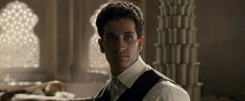 Movie still from “Killer Elite” (2011), directed by Gary McKendry – A person wearing a suit and tie; Close Up shot, Low angle