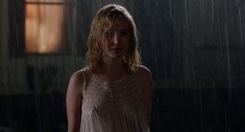 Movie still from “Killer Joe” (2011), directed by William Friedkin – A woman standing in the middle of a rain storm; Medium shot, Over the shoulder angle