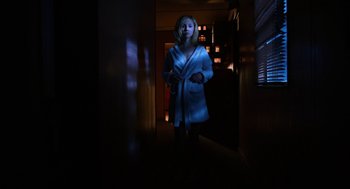 Movie still from “Killer Joe” (2011), directed by William Friedkin – A woman in a robe standing in a dark room; Wide shot, Low angle